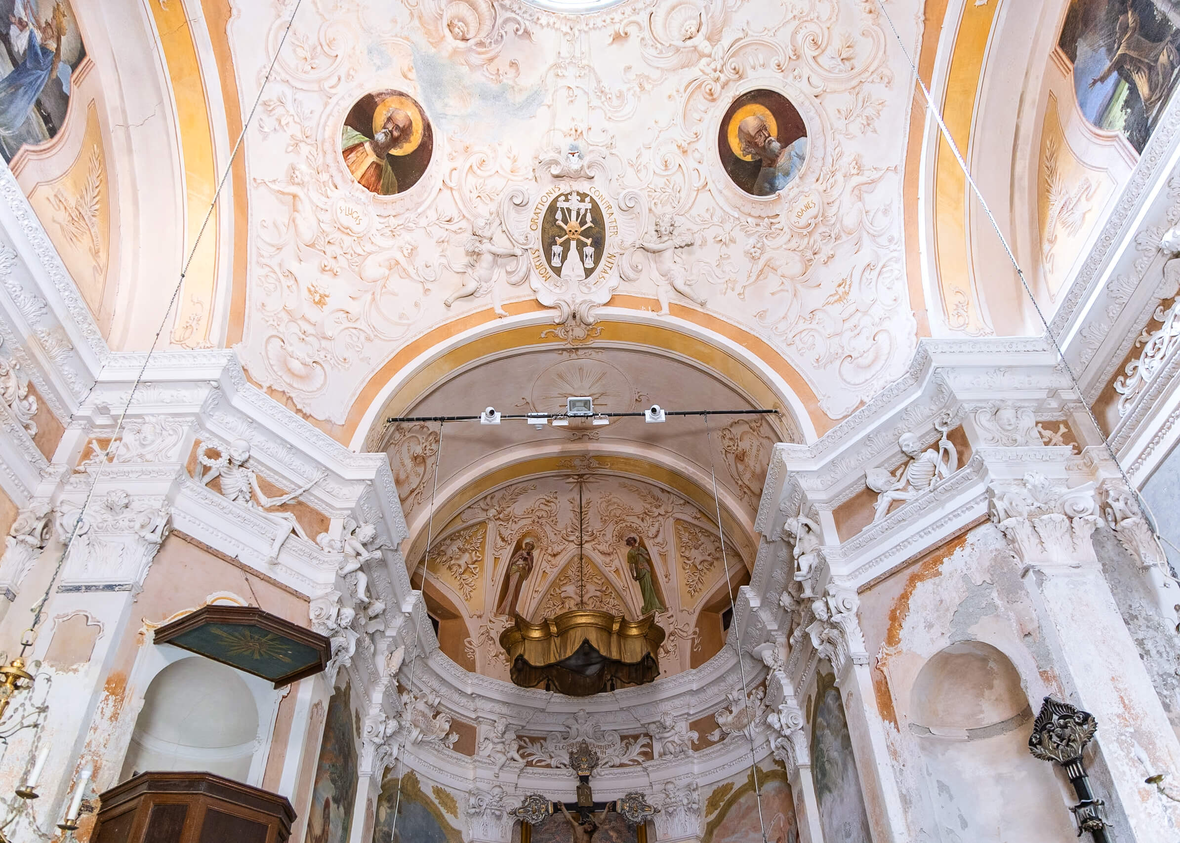 The ornate ceiling of the Oratorio in Monterosso al Mare, Cinque Terre. The intricate frescoes and detailed stucco work depict religious figures and symbols, showcasing the baroque artistry. This historical site is a must-visit for culture enthusiasts in Cinque Terre.