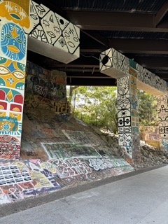 Brightly painted murals and colorful graffiti cover the walls under a bridge on the Atlanta Beltline Eastside Trail. Discovering vibrant street art is a must-see activity when looking for things to do in Atlanta Georgia.