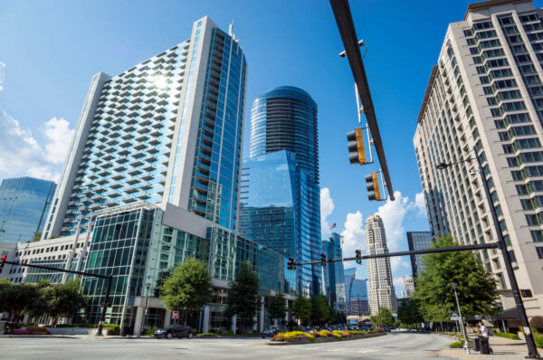 Downtown Atlanta's vibrant skyline with towering modern buildings under a clear blue sky, viewed from a bustling city street. Strolling through downtown is a quintessential activity when exploring things to do in Atlanta, Georgia.